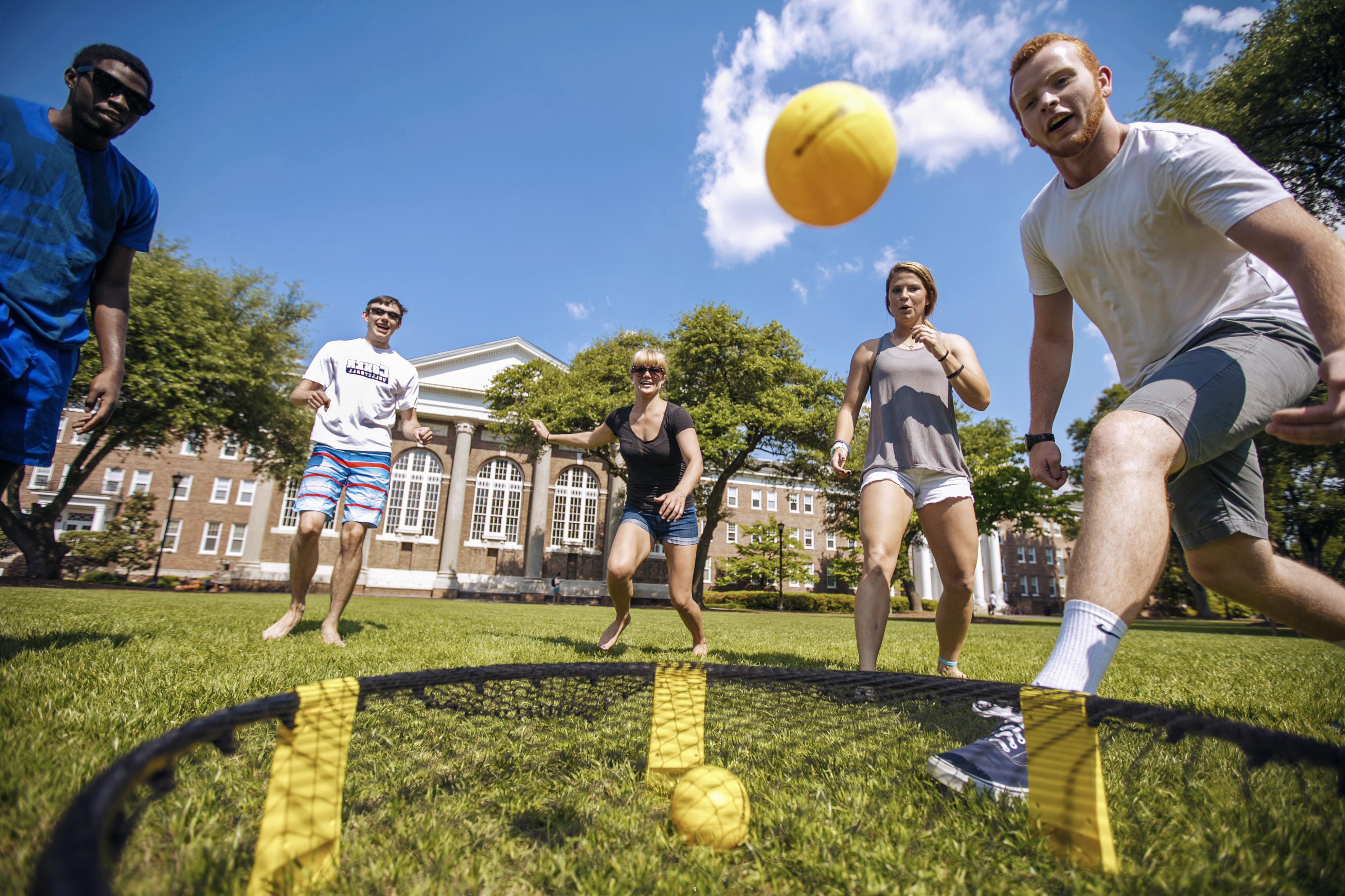 一个阳光明媚的下午，学生们在戴维森大厅的草坪上踢球